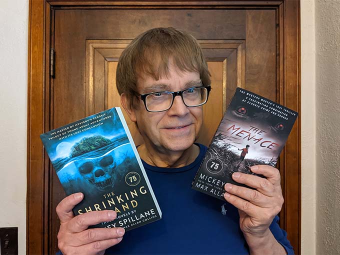 M.A.C. holding copies of The Menace and The Shrinking Island