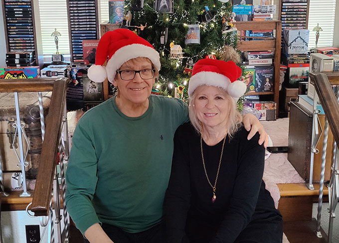 Barbara Allan sitting in front of a Christmas tree.