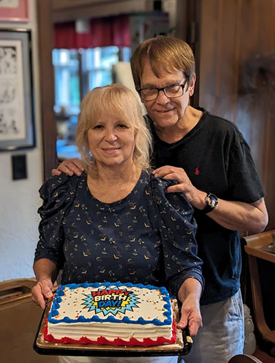 Barbara and Max posing with a birthday cake.