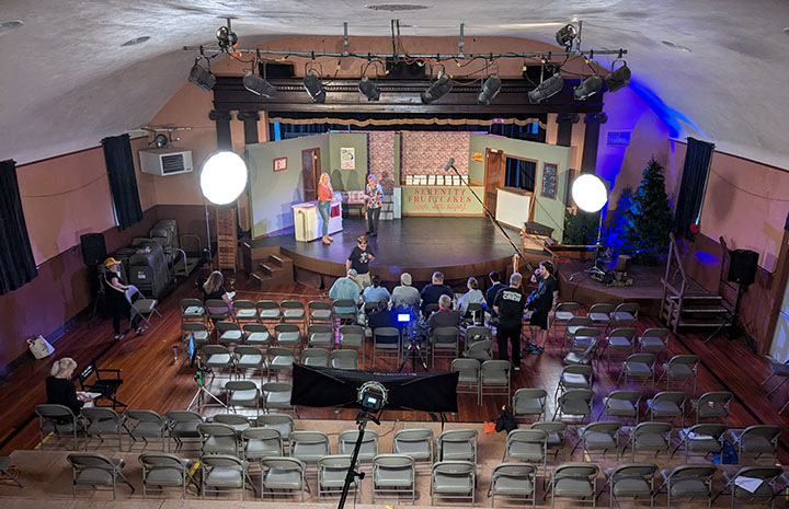 Death by Fruitcake, auditorium set with cast and crew at work.