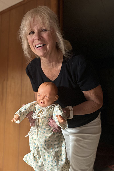 In the prop area, Barbara Collins gives Baby Jesus the heave ho to borrow some of the hay in His manager.